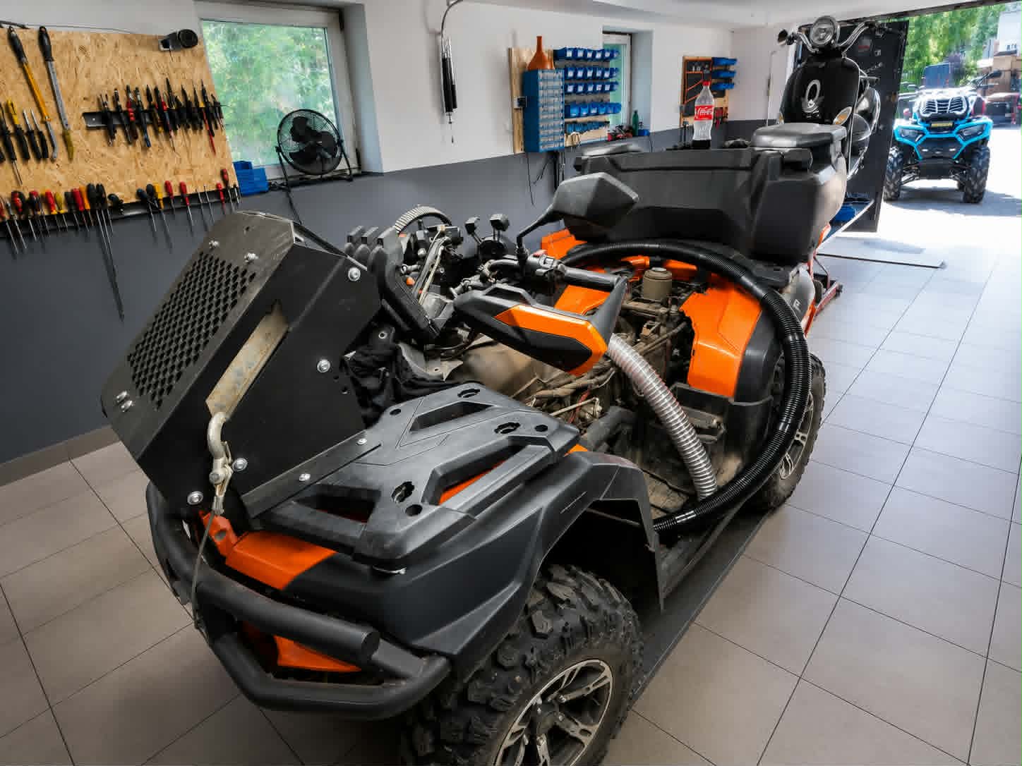 Mechanik przygotowujący quad do sezonu off-road, kontrola opon i zawieszenia