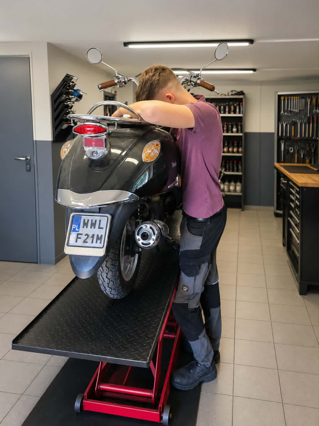 Mechanik wykonujący przegląd skutera drogowego w warsztacie